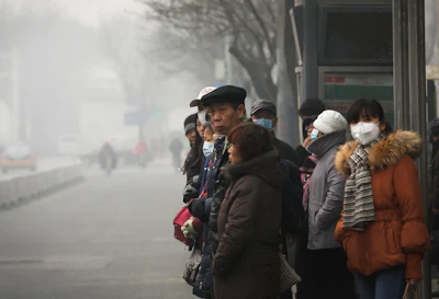 Commuters, some wearing masks to protect themselves from pollutants, wait at a bus stand on a heavily polluted day in Beijing. (AP Photo/Andy Wong)