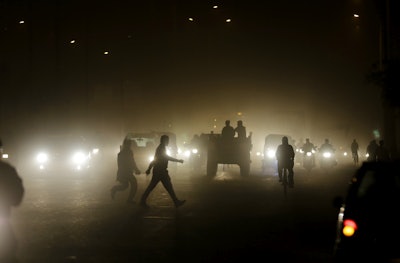 Pedestrians walk through a busy road in New Delhi, India. (AP Photo/Altaf Qadri)