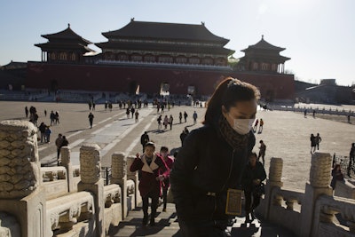 A woman wears a mask as she visits the Forbidden City during a sunny day in Beijing Friday, Dec. 18, 2015. Residents in the Chinese capital are preparing for its second smog red alert as a wave of smog is forecasted to settle over the city from Saturday to Tuesday. (AP Photo/Ng Han Guan)