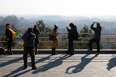 Visitors take photos from a pavilion overlooking the Forbidden City in Beijing Friday, Dec. 18, 2015. (AP Photo/Ng Han Guan)