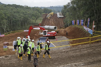 Indonesian President Joko Widodo, right wearing a white helmet, leads a pack of people as he inspects the construction site of the high-speed railway. (AP Photo/Dita Alangkara)