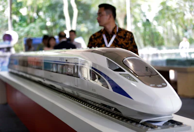 A visitor walks past a model of the high-speed train which will connect the capital city of Jakarta to the country's fourth largest city, Bandung, during the groundbreaking ceremony for the construction of its railway in Cikalong Wetan, West Java, Indonesia. (AP Photo/Dita Alangkara)