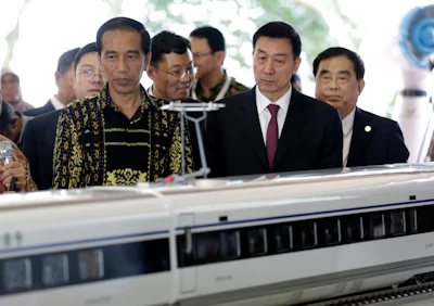Indonesian president Joko Widodo, left, inspects a model of the high-speed train which will connect the capital city of Jakarta to the country's fourth largest city, Bandung, with President of China Railway Corp. Sheng Guangzu, right, Chinese State Councillor Wang Yong, second right, and Chinese Ambassador to Indonesia Xie Feng, third right. (AP Photo/Dita Alangkara)