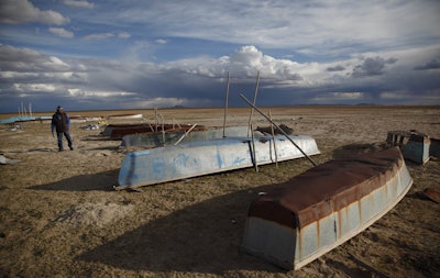 A fisherman walks along the abandoned boats in the dried up Lake Poopo, on the outskirts of Untavi, Bolivia. The overturned fishing skiffs lie abandoned on the dried up former shores of what was Bolivia’s second-largest lake. (AP Photo/Juan Karita)