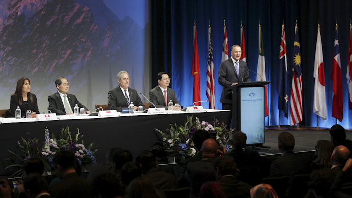 New Zealand Prime Minister John Key, right, speaks to delegates at the signing of the Trans-Pacific Partnership Agreement in Auckland, New Zealand, Thursday, Feb. 4, 2016. Trade ministers from 12 Pacific Rim countries including the United States have ceremonially signed the free-trade deal. (David Rowland/SNPA via AP)