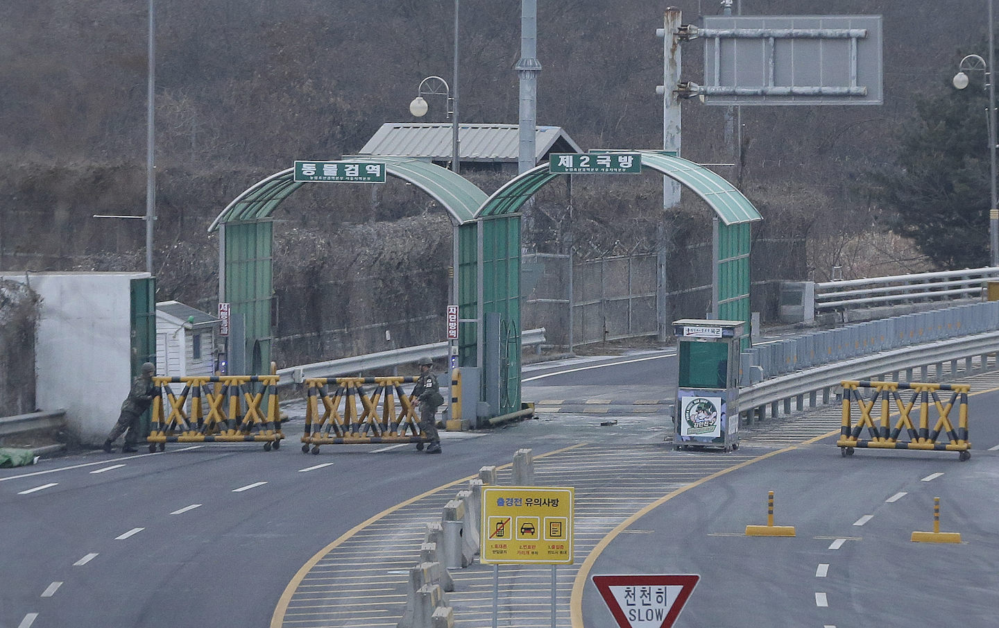 South Korean Army soldiers move barricades to close the road at the customs, immigration and quarantine office near the border village of Panmunjom in Paju, South Korea. (AP Photo/Ahn Young-joon)
