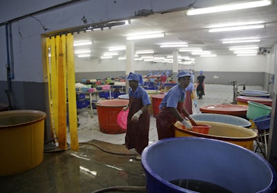 Workers react during a raid on a shrimp shed conducted by Thailand's Department of Special Investigation in Samut Sakhon, Thailand. (AP Photo/Dita Alangkara, File)