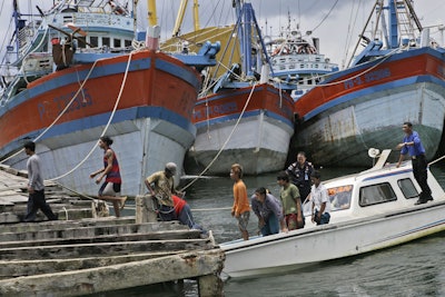 Burmese fishermen arrive at the compound of Pusaka Benjina Resources to report themselves for departure to leave the fishing company in Benjina, Aru Islands, Indonesia as hundreds of foreign fishermen rush at the chance to be rescued from the isolated island on April 3, 2015. (AP Photo/Dita Alangkara, File)