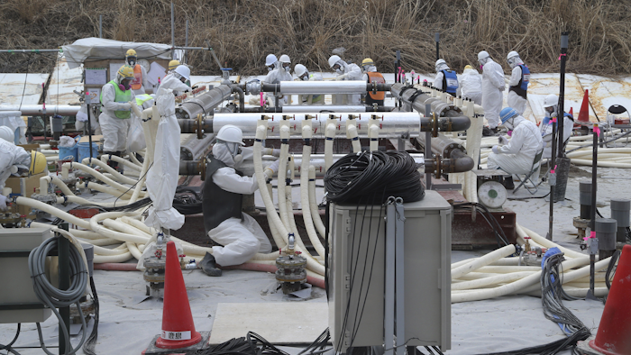 Workers wearing protective gears install a trial model of the underground frozen wall at the Fukushima Dai-ichi nuclear power plant in Okuma, Fukushima prefecture, northeastern Japan in their attempt to stop the leakage of radioactive water that has accumulated at the crippled nuclear power plant. (AP Photo/Koji Sasahara, Pool, File)