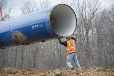 In this March 17, 2016 file photo, laborers place a 50 foot section of the Karegnondi Water Authority pipeline near Oregon Twp, Mich. After months of national attention on lead-tainted drinking water in Flint, many are starting to ask questions about the 74-mile pipeline being built from Lake Huron to the struggling former auto manufacturing powerhouse. (David Guralnick /Detroit News via AP File)