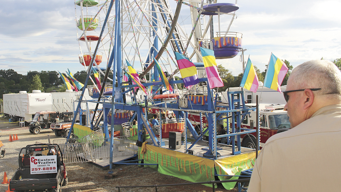 Law enforcement cordon off the area surrounding the Ferris wheel Monday, Aug. 8, 2016, after three people fell from the ride during a county fair in Greenville, Tenn. Baileyton police Officer Kenneth Bitner is visible at right. Police say one of three people who fell from the Ferris wheel suffered a head injury and remains hospitalized in serious condition. (O.J. Early/The Greeneville Sun via AP)