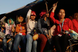 In this Feb. 17, 2016, photo, Cambodian garment workers are transported from the factory to their home at the outskirts of Phnom Penh, Cambodia. The Cambodian government has agreed to raise the minimum wage for clothing and footwear workers, a move that could help placate workers in the country's biggest export industry on Thursday, Sept. 29, 2016. (AP Photo/Heng Sinith)