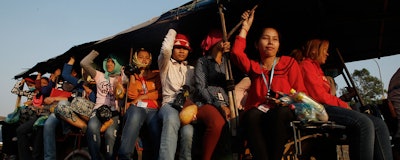 In this Feb. 17, 2016, photo, Cambodian garment workers are transported from the factory to their home at the outskirts of Phnom Penh, Cambodia. The Cambodian government has agreed to raise the minimum wage for clothing and footwear workers, a move that could help placate workers in the country's biggest export industry on Thursday, Sept. 29, 2016. (AP Photo/Heng Sinith)