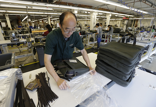 In this Wednesday, Aug. 31, 2016, photo, Ying Chau places a completed piece of luggage into a plastic bag at the C.C. Filson Co. manufacturing facility, in Seattle. On Monday, Oct. 3, 2016, the Institute for Supply Management, a trade group of purchasing managers, issues its index of manufacturing activity for September. (AP Photo/Ted S. Warren)