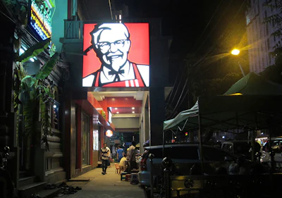 In this Friday, Oct. 7, 2016 photo, a sign of KFC’s grinning Colonel Sanders and his goatee is lit outside its outlet in Yangon, Myanmar. The end of most U.S. sanctions against Myanmar is raising hopes western businesses will join the rush to invest in Myanmar that up to now has been dominated by China and other Asian countries. But much hinges on how the government led by Nobel laureate Aung San Suu Kyi reshapes the country’s outdated laws and other policies. (AP Photo/Elaine Kurtenbach)