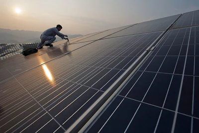 In this Aug. 21, 2016 photo, a worker performs maintenance work on solar panels at a photovoltaic power station in Songxi county in southeast China's Fujian province. Solar panels are among a series of industries from steel and cement to wind turbines in which Chinese production capacity soared during the past decade's economic boom until it vastly exceeded demand. (Chinatopix via AP)