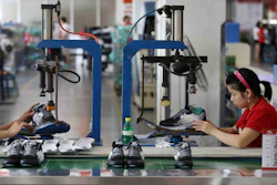 Workers assemble sneakers at a factory in Jinjiang city in southeast China's Fujian province. (Chinatopix Via AP, File)
