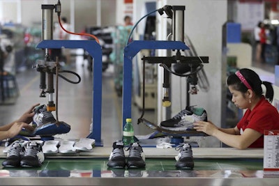 Workers assemble sneakers at a factory in Jinjiang city in southeast China's Fujian province. (Chinatopix Via AP, File)