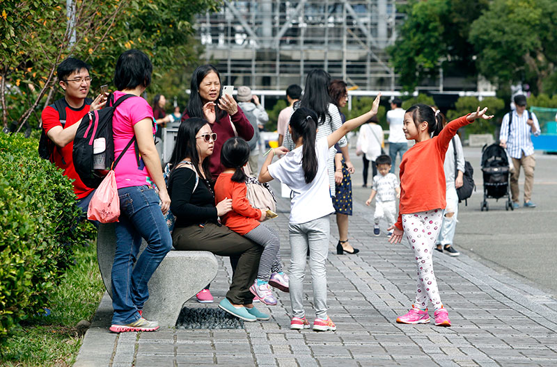 In this Sunday, Nov. 20, 2016 photo, Taiwanese people enjoy their weekend at the Sun Yat-sen Memorial Hall in Taipei, Taiwan. Taiwan will soon start mandating two-day weekends for its longsuffering workforce. The changed labor standards reflect desires for better work-life balance in this affluent, industrialized island. A new law due to be signed by President Tsai Ing-wen before the year’s end requires companies to give workers two full days off per week. (AP Photo/Chiang ying-ying)