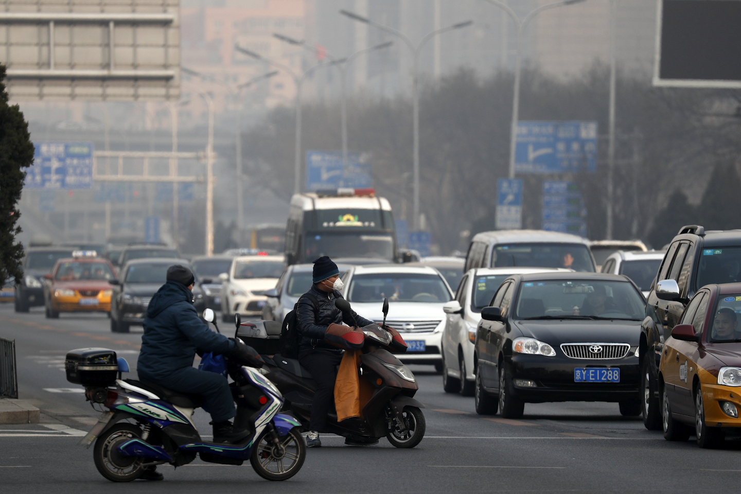 China's capital and other northern cities have banned half of all vehicles from city streets and ordered factories, schools and construction sites closed in response to a five-day smog red alert. (AP Photo/Andy Wong)
