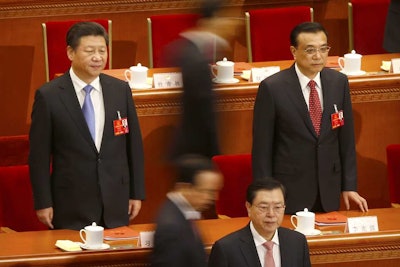 Chinese President Xi Jinping, left, and Premier Li Keqiang, right, stand as delegates file past before the start of the closing session of the annual National People's Congress at the Great Hall of the People in Beijing, Wednesday, March 16, 2016. (AP Photo/Mark Schiefelbein)