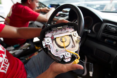 A Honda technician works on an air bag during a free replacement event in Kuala Lumpur, Malaysia. Five Malaysians have died in accidents linked to faulty Takata air bags that are at the center of one of the world&rsquo;s largest auto recalls. (AP Photo/Lim Huey Teng)