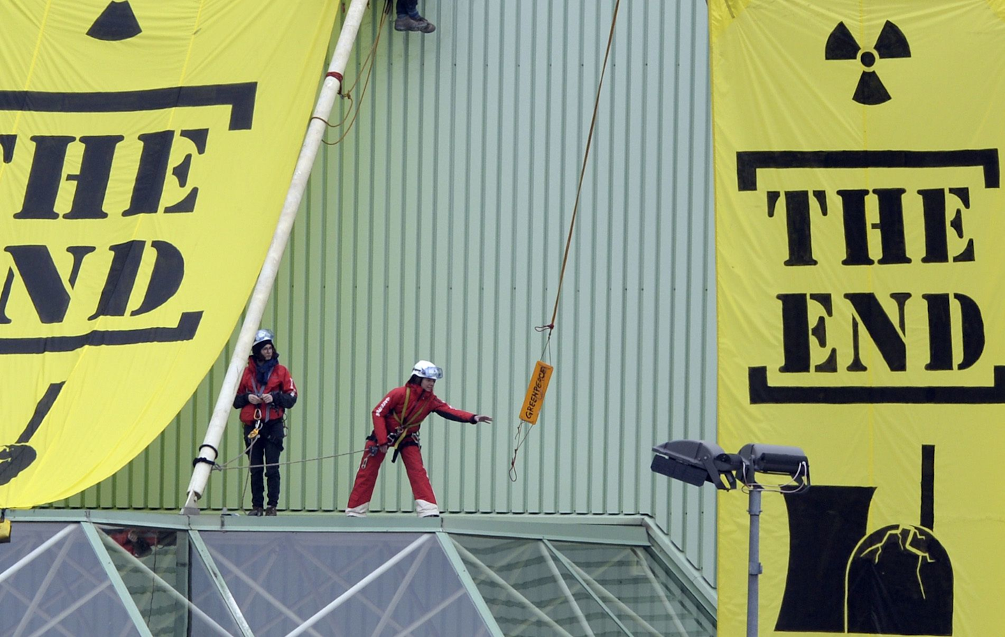 In this March 5, 2014 file picture Greenpeace activists hang banners saying 'The End', at a building of the Nuclear power plant Beznau near Doettingen, Switzerland. Swiss voters are supporting a referendum to withdraw the country from nuclear power in favor of renewable energy. A projection from Sunday's May 21, 2017 referendum shows a majority of cantons (states) voted for the plan. Under Switzerland's direct democracy system, initiatives need a majority of both cantons and votes to pass. The projection for SRF public television showed 58 percent of voters in favor and 42 percent against the proposal. (Urs Flueeler/Keystone via AP,file)