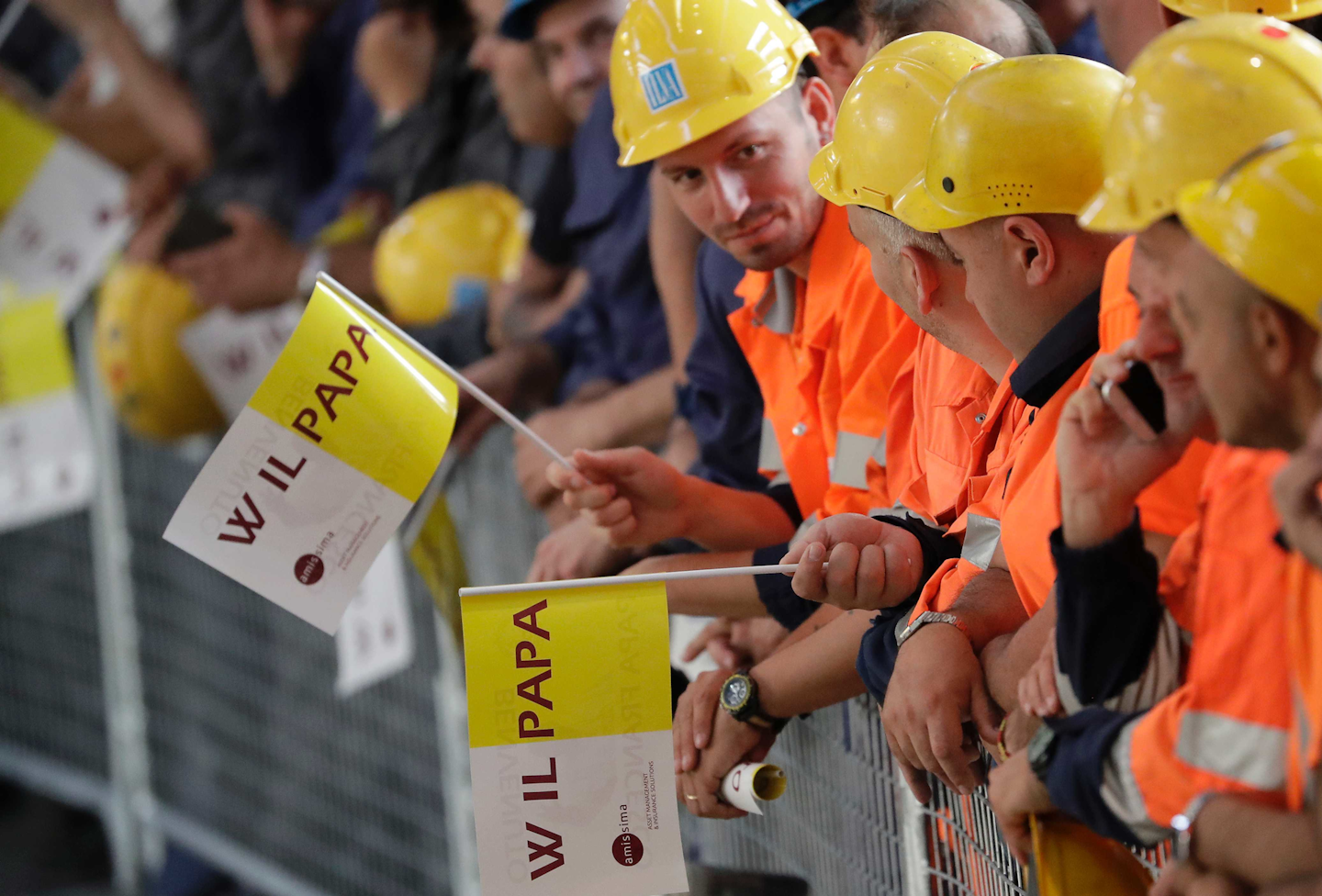 Ilva factory steel workers wait for Pope Francis to arrive for his one-day pastoral visit to Genoa, Italy, Saturday, May 27, 2017. (AP Photo/Antonio Calanni)
