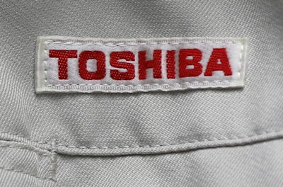 In this Thursday, June 15, 2017, photo, the logo of Toshiba Corp., Japan's electronics and energy company, is seen on a worker's jacket in Yokosuka, near Tokyo. Tokyo-based Toshiba, whose U.S. nuclear unit Westinghouse Electric Co. filed for bankruptcy protection in March, said Friday it received an extension until Aug. 10 to give its earnings report for the fiscal year that ended in March. (AP Photo/Shuji Kajiyama, File)