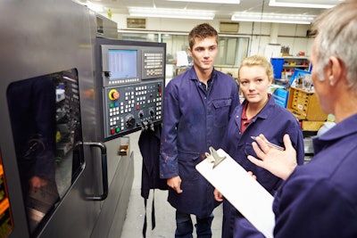 Engineer Teaching Apprentices To Use Computerized Lathe 458860281 2122x1415