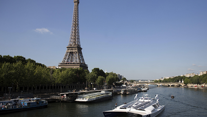 The Energy Observer, a former race boat turned into a autonomous navigation with hydrogen, sails past the Eiffel Tower on the Seine river in Paris. A boat that fuels itself is setting off from Paris on a six-year, round-the-world journey that its designers hope serves as a model for emissions-free energy networks of the future. (AP Photo/Kamil Zihnioglu, File)