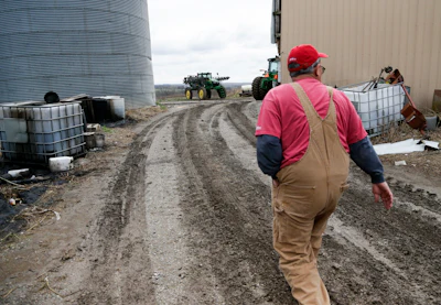 In this Tuesday, April 4, 2017, file photo, Blake Hurst, a corn and soybean farmer and president of the Missouri Farm Bureau, walks to the tractor shed on his farm in Westboro, Mo. U.S. President Donald Trump has vowed to redo the North American Free Trade Agreement, but NAFTA has widened access to Mexican and Canadian markets, boosting U.S. farm exports and benefiting many farmers. Hurst says NAFTA has been good for his business and worries that he'll lose out in a renegotiation. (AP Photo/Nati Harnik, File)