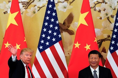 In this Thursday, Nov. 9, 2017, file photo, U.S. President Donald Trump waves next to Chinese President Xi Jinping after attending a joint press conference at the Great Hall of the People in Beijing. China's main official news agency is warning U.S.-Chinese relations will face 'more pressure and challenges' following President Donald Trump's decision to label Beijing a rival. (AP Photo/Andy Wong, File)