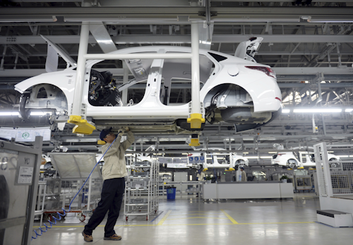 A staff member works on an assembly line at a Beijing Hyundai Motor auto plant in Cangzhou in northern China's Hebei province. An industry group says China's auto sales shrank in December and ended 2017 up just 1.4 percent over the previous year as the popularity of SUVs helped to offset contraction in demand for sedans. (Chinatopix via AP)