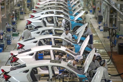 In this Feb. 6, 2017 photo, workers assemble Honda Civics on an assembly line at a Dongfeng Honda automotive plant in Wuhan in central China's Hubei province. China’s economy expanded at a 6.9 percent pace in 2017, faster than expected and the first annual increase in seven years, the government reported Thursday, Jan. 18, 2018. (Chinatopix via AP)