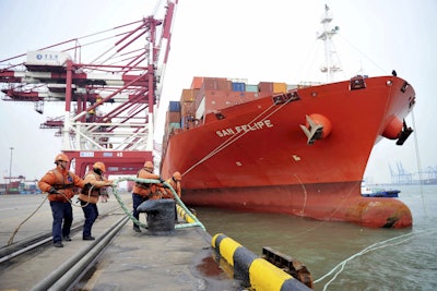 Chinese border police officers watch the arrival of a container ship at a port in Qingdao in eastern China's Shandong province, Thursday, March 8, 2018. Image credit: Chinatopix via AP