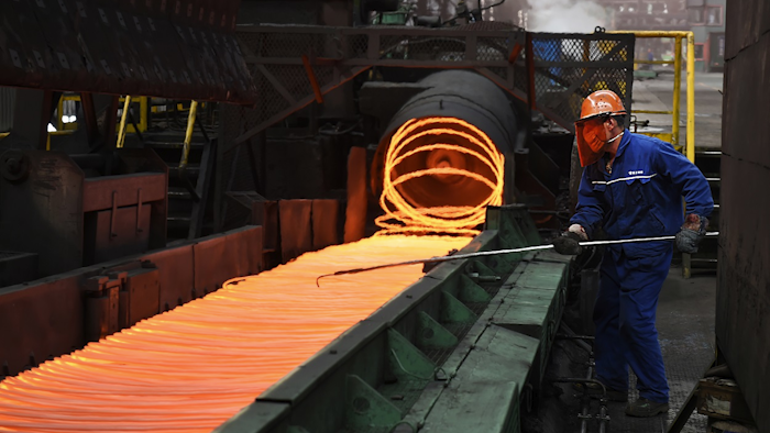 vIn this March 5, 2018 photo, a worker manipulates coils of steel at Xiwang Special Steel in Zouping County in eastern China's Shandong province. Image credit: Chinatopix via AP