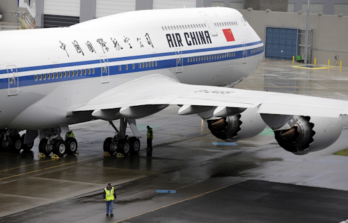 In this Sept. 29, 2014, file photo, a worker walks next to first Boeing 747-8 Intercontinental airplane to be delivered to Air China in Everett, Wash., before a delivery ceremony. Image credit: AP Photo/Ted S. Warren, File