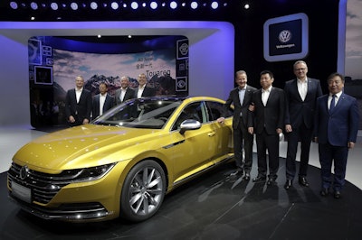 Herbert Diess, CEO of Volkswagen, fourth from right, poses with officials and the newly unveiled Volkswagen CC car model during the media day of the China Auto Show in Beijing, Wednesday, April 25, 2018. Image credit: AP Photo/Andy Wong