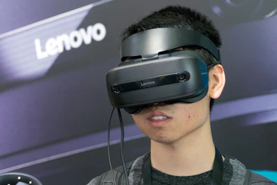 A man wears a virtual reality headset at the Chinese mobile phone company Lenovo exhibition at the Consumer Electronics Show Asia 2018 in Shanghai, China on Friday, June 15, 2018. Image credit: AP Photo/Sam McNeil