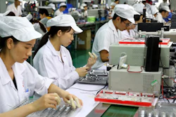 In this June 23, 2018, photo, workers inspect the micro-motors for handsets at a factory in Huaibei in central China's Anhui province. Image credit:Chinatopix via AP