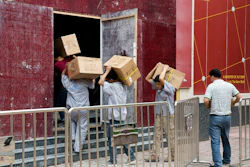 Workers carry boxes of LED lights into a renovation site in Beijing, China, Tuesday, July 3, 2018. Image credit: AP Photo/Ng Han Guan