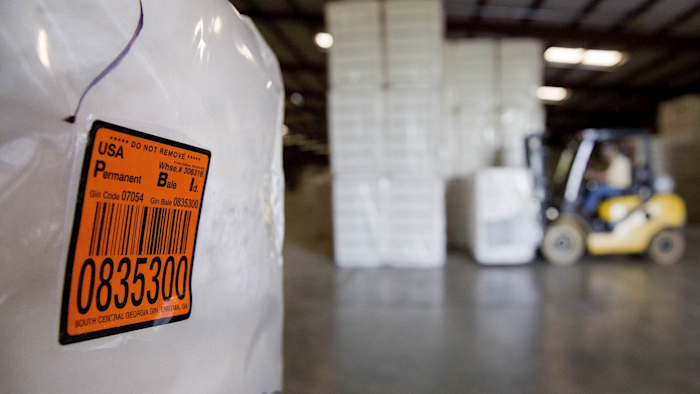 In this June 21, 2018, file photo, a bale of cotton sits packed and labeled while waiting to be shipped from the South Central Georgia Gin Company in Enigma, Ga. Image credit: AP Photo/Steven Senne