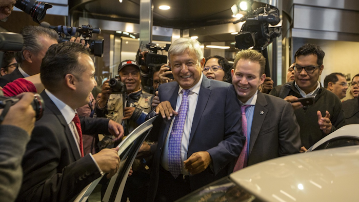 Mexico's President-elect Andres Manuel Lopez Obrador is surrounded by the press as he leaves a hotel where he gave a press conference in Mexico City, Monday, July 9, 2018. Image credit: AP Photo/Moises Castillo