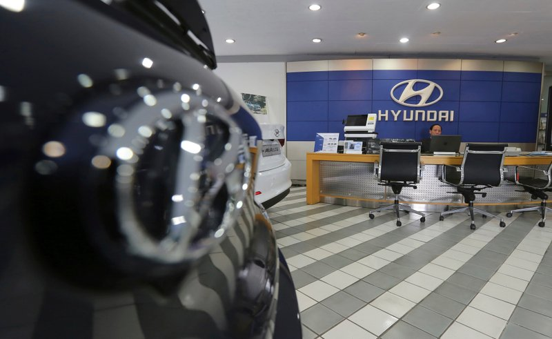 An employee of Hyundai Motor Co. waits for customers at the company's showroom in Seoul, South Korea. Hyundai Motor Co.'s labor union said Thursday, July 12, 2018, steep auto tariffs that the U.S. is considering could cost tens of thousands of U.S. jobs. (AP Photo/Ahn Young-joon)