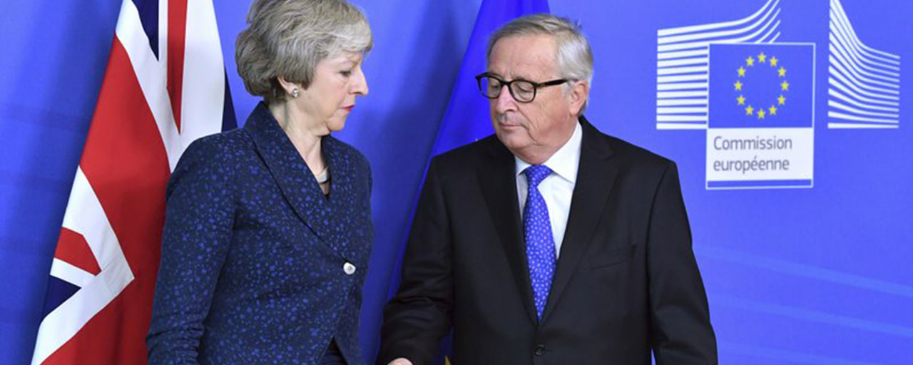 In this Thursday, Feb. 7, 2019 photo European Commission President Jean-Claude Juncker, right, prepares to shake hands with British Prime Minister Theresa May, left, before their meeting at the European Commission headquarters in Brussels, Belgium. EU Commission President Jean-Claude Juncker says he can't rule out that a delayed Brexit could mean the United Kingdom would participate in this spring's European Parliament election. (AP Photo/Geert Vanden Wijngaert)