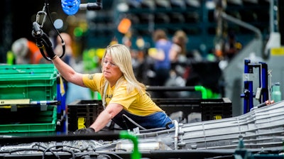 In this June 12, 2019 file photo, General Motors employees work on the chassis line as they build the frame, power train and suspension onto the truck's body at the Flint Assembly Plant in Flint, MI.