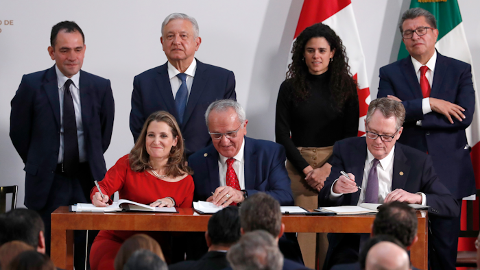 Deputy Prime Minister of Canada Chrystia Freeland, left, Mexico's top trade negotiator Jesus Seade, center, and U.S. Trade Representative Robert Lighthizer, sign an update to the North American Free Trade Agreement, at the national palace in Mexico City on Tuesday, Dec. 10. Observing from behind are Mexico's Treasury Secretary Arturo Herrera, left, Mexico's President Andres Manuel Lopez Obrador, second left, Mexico's Labor Secretary Maria Alcade, third left, and The President of the Mexican Senate Ricardo Monreal.