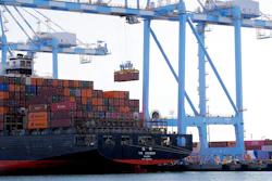 In this Nov. 4, 2019 photo, cargo cranes are used to take containers off of a Yang Ming Marine Transport Corporation boat at the Port of Tacoma in Tacoma, WA.