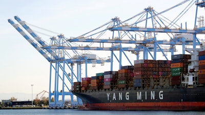 In this Nov. 4, 2019 file photo, cargo cranes are used to take containers off of a Yang Ming Marine Transport Corporation boat at the Port of Tacoma in Tacoma, WA.